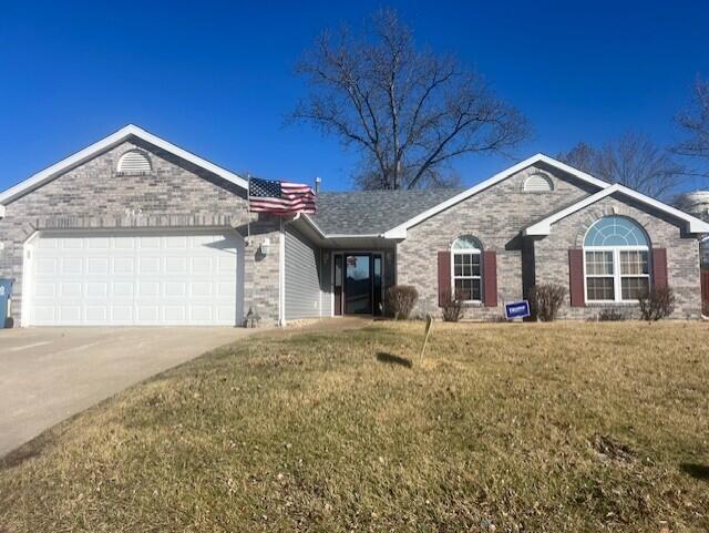 ranch-style house with a garage, a front yard, concrete driveway, and brick siding