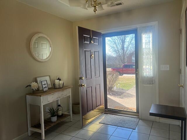 foyer featuring visible vents, baseboards, and light tile patterned floors