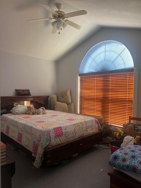 bedroom with carpet floors, a ceiling fan, and lofted ceiling