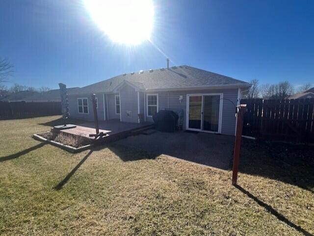 rear view of house with a yard, a patio area, and fence