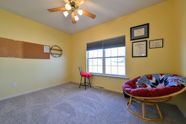 living area featuring a ceiling fan, baseboards, visible vents, and carpet flooring