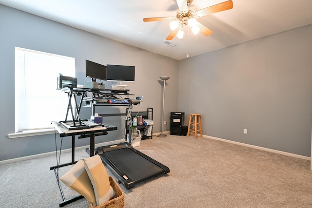 exercise room featuring carpet floors, a ceiling fan, and baseboards