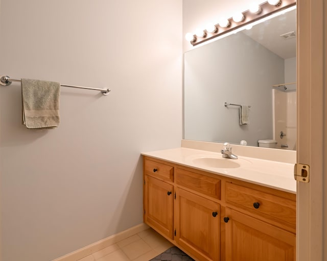 bathroom with baseboards, visible vents, toilet, tile patterned floors, and vanity