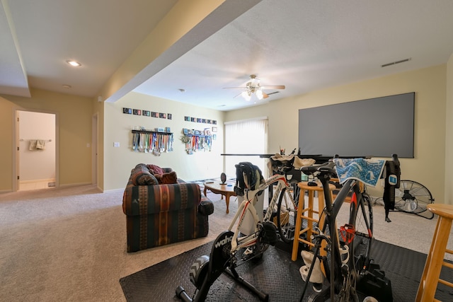 exercise area featuring carpet floors, visible vents, baseboards, and a ceiling fan