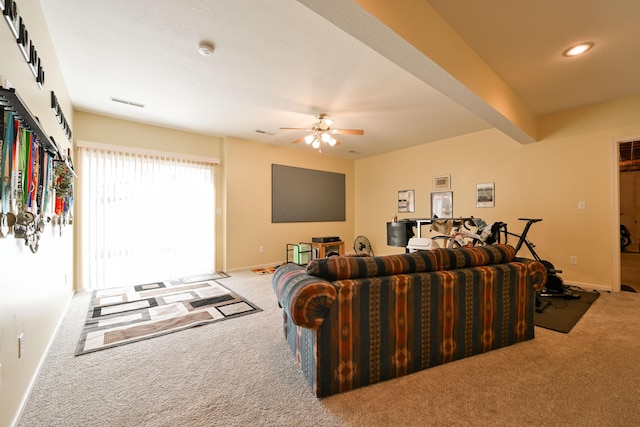 living area featuring carpet, visible vents, ceiling fan, beamed ceiling, and baseboards