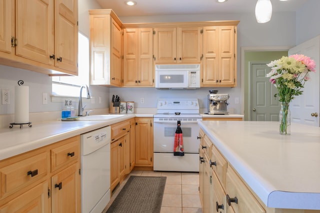 kitchen with white appliances, light countertops, light brown cabinets, a sink, and light tile patterned flooring