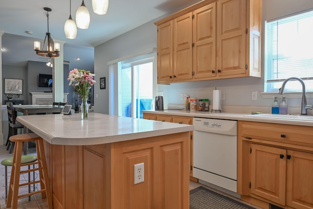 kitchen with a breakfast bar, white dishwasher, light countertops, and a sink