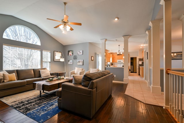 living room with baseboards, hardwood / wood-style flooring, ceiling fan, vaulted ceiling, and ornate columns