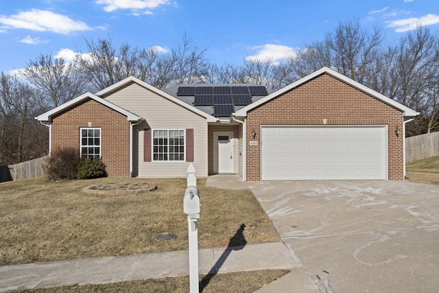 ranch-style home with a garage, concrete driveway, fence, roof mounted solar panels, and brick siding