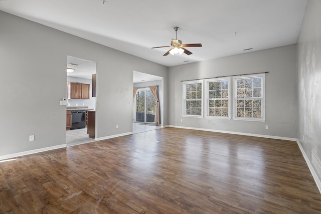 unfurnished living room featuring ceiling fan, baseboards, and wood finished floors