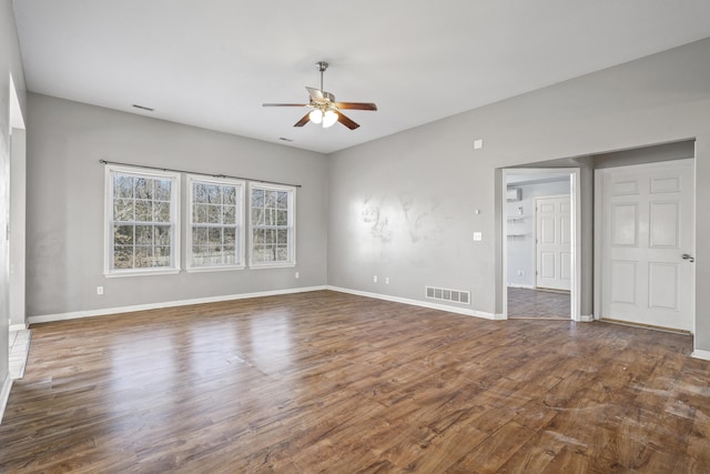 interior space featuring dark wood-style floors, baseboards, visible vents, and a ceiling fan