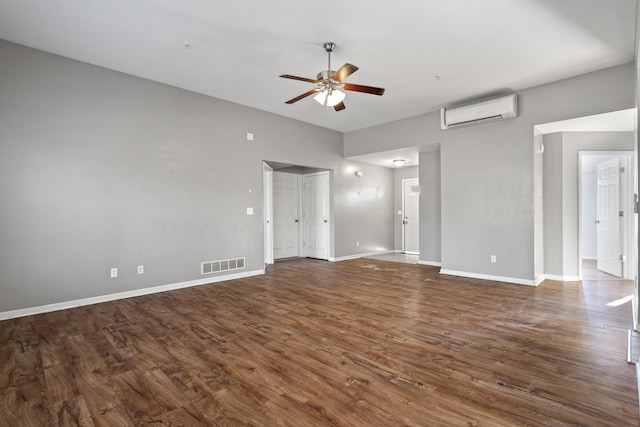 unfurnished living room with dark wood-type flooring, a wall mounted AC, visible vents, and baseboards