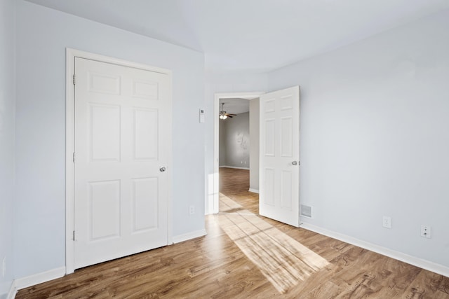 unfurnished bedroom featuring wood finished floors and baseboards