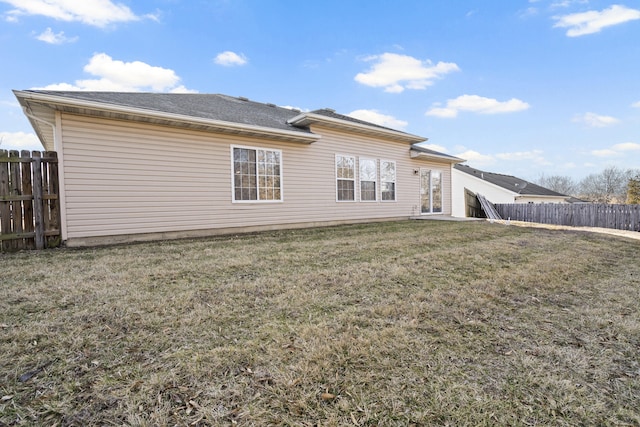 back of property featuring a yard and fence