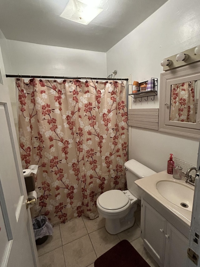 bathroom with curtained shower, vanity, toilet, and tile patterned floors