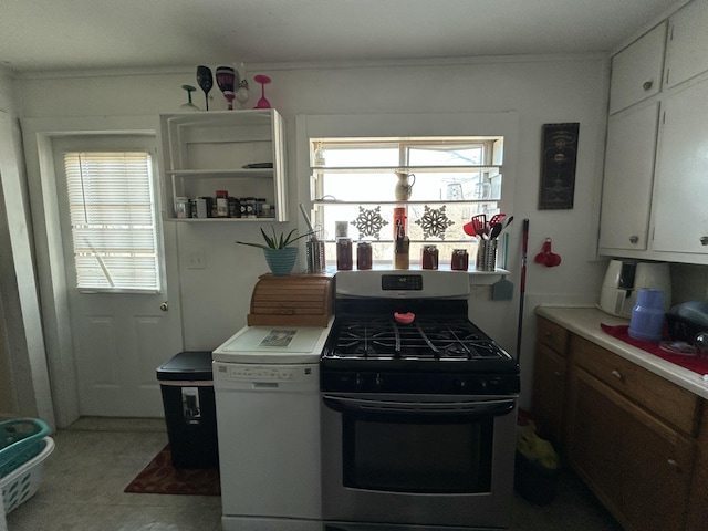 kitchen featuring stainless steel gas range, white cabinets, and light countertops