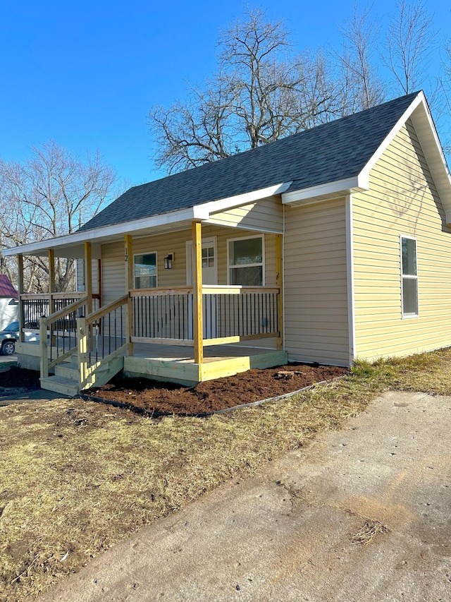 view of front of home with covered porch and a shingled roof