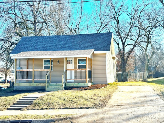 bungalow-style home with covered porch and a shingled roof