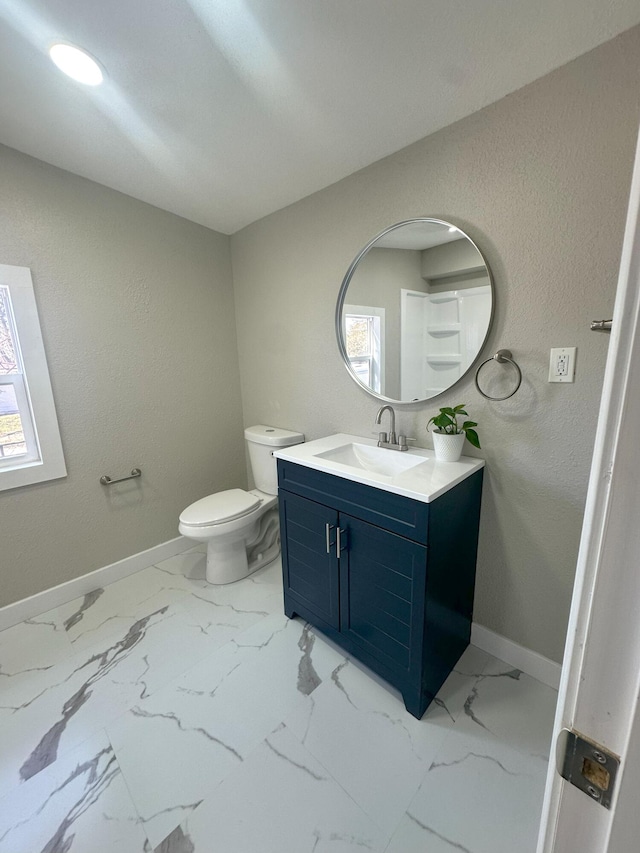 bathroom featuring toilet, a wealth of natural light, vanity, and baseboards