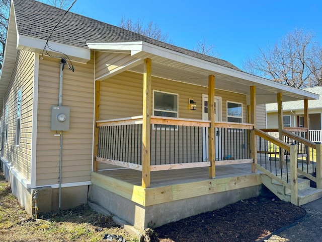 exterior space featuring a shingled roof and a porch