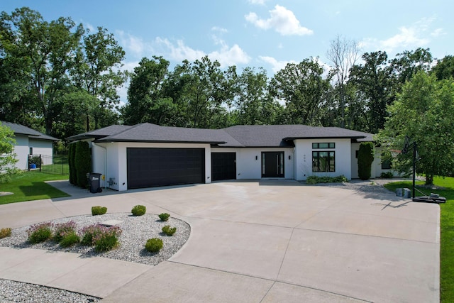 view of front of property featuring a front yard, concrete driveway, an attached garage, and stucco siding