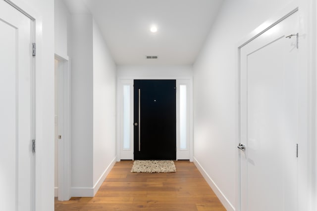 doorway to outside with light wood-style floors, baseboards, and visible vents