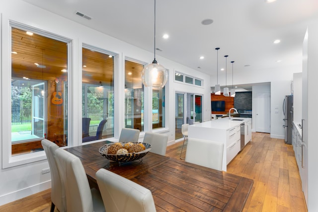 dining room featuring light wood finished floors, visible vents, baseboards, and recessed lighting