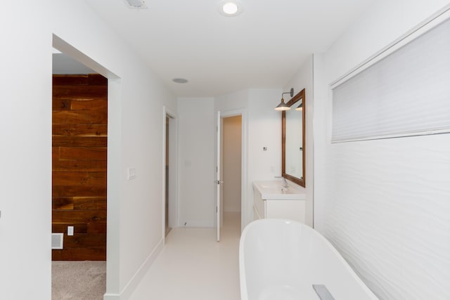 full bathroom featuring a soaking tub, wooden walls, visible vents, and vanity