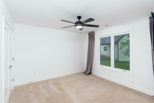 carpeted empty room featuring ceiling fan, visible vents, and baseboards