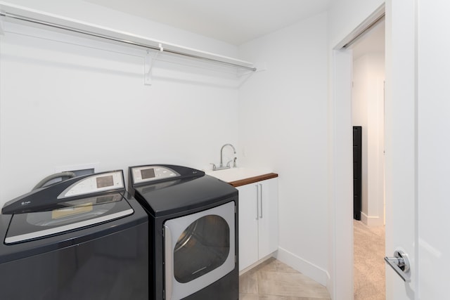 washroom with light carpet, cabinet space, washer and clothes dryer, and baseboards