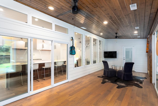 sunroom / solarium with wood ceiling, visible vents, and a ceiling fan