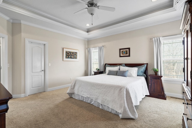 bedroom featuring a raised ceiling, light colored carpet, baseboards, and multiple windows