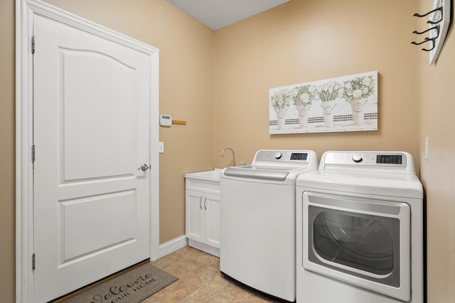 clothes washing area with a sink, washing machine and dryer, cabinet space, and baseboards