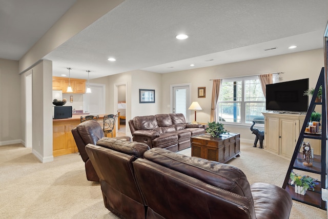 living area with recessed lighting, light carpet, a textured ceiling, and baseboards