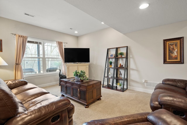 living area with baseboards, visible vents, and light colored carpet