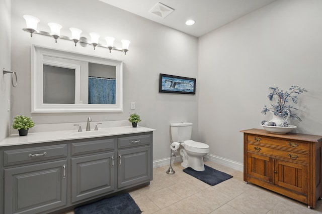 bathroom with tile patterned flooring, baseboards, vanity, and toilet