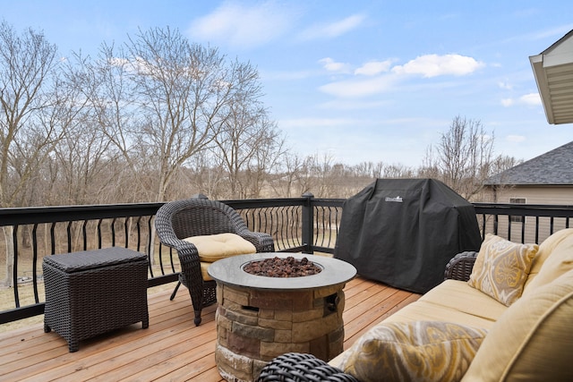 deck with an outdoor fire pit and a grill