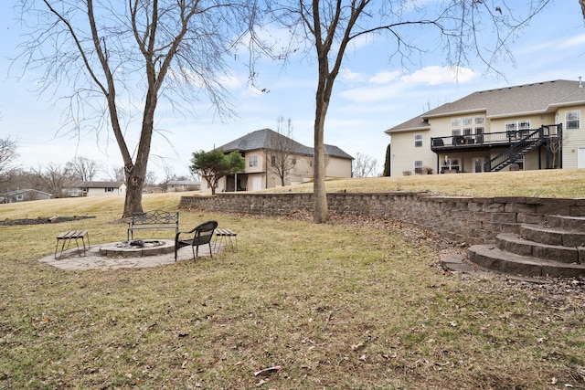 view of yard featuring a fire pit, stairs, and a wooden deck