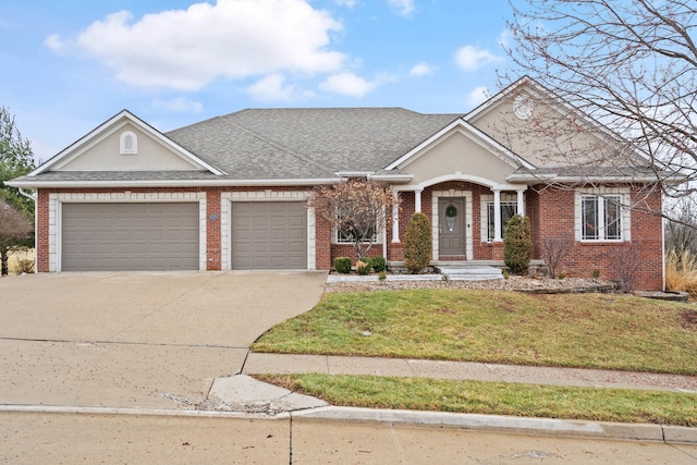 view of front facade with driveway, brick siding, an attached garage, and a front yard