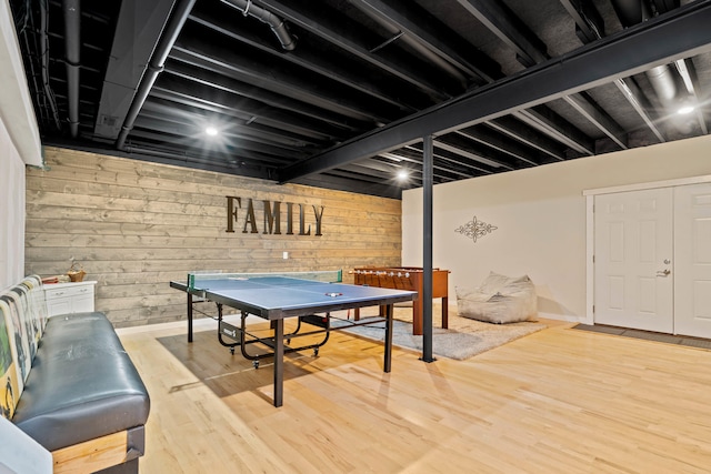 recreation room with wood walls and wood finished floors