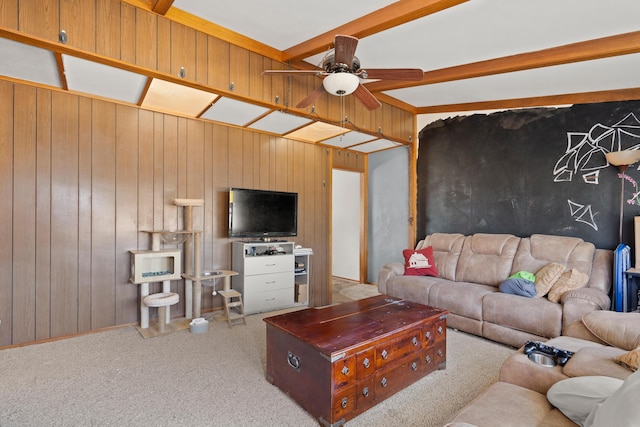 living room featuring beam ceiling, wood walls, and carpet floors