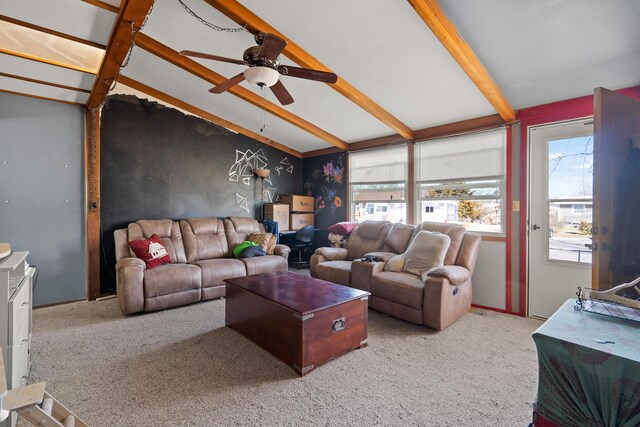 living area with carpet flooring, a ceiling fan, and vaulted ceiling with beams