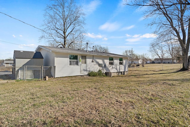 back of house with a lawn and fence