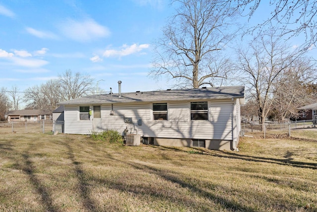 rear view of house with a yard and fence