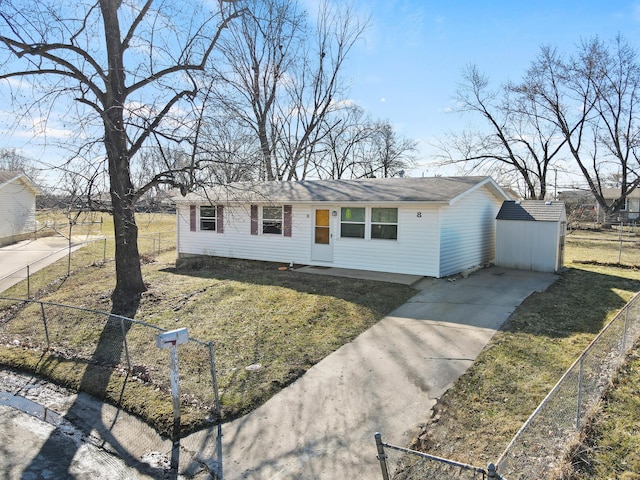 ranch-style home featuring a front yard, an outbuilding, a shed, and fence