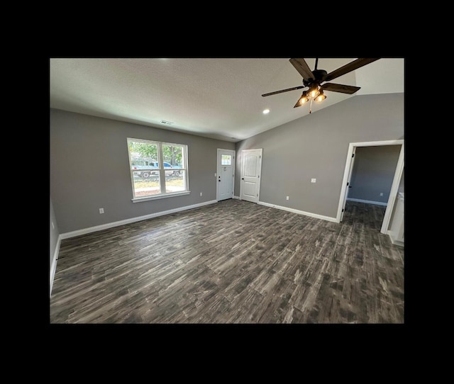 unfurnished living room featuring ceiling fan, a textured ceiling, lofted ceiling, baseboards, and dark wood-style floors