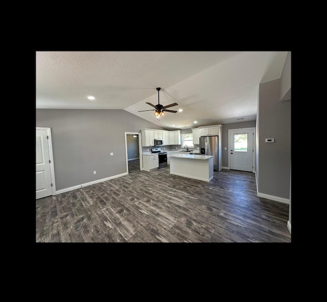 kitchen with lofted ceiling, dark wood-style flooring, a kitchen island, white cabinetry, and open floor plan