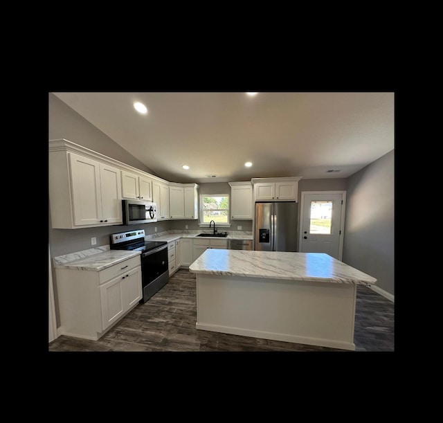 kitchen featuring stainless steel appliances, a center island, white cabinets, and a sink