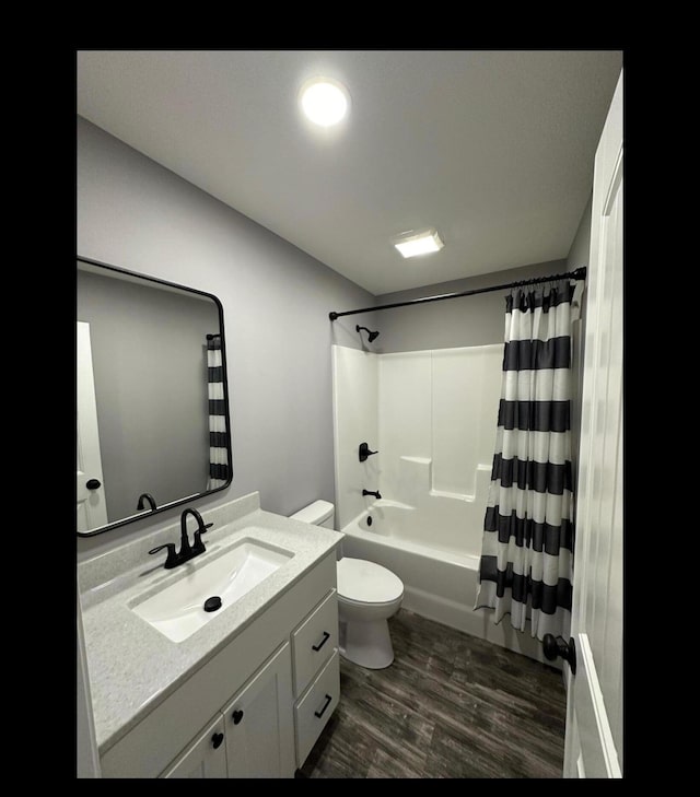 bathroom featuring toilet, shower / tub combo, wood finished floors, and vanity