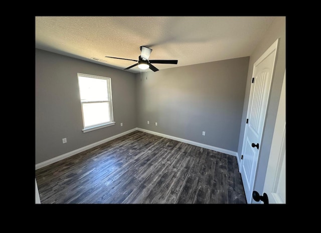 unfurnished bedroom featuring a textured ceiling, dark wood-type flooring, visible vents, and baseboards